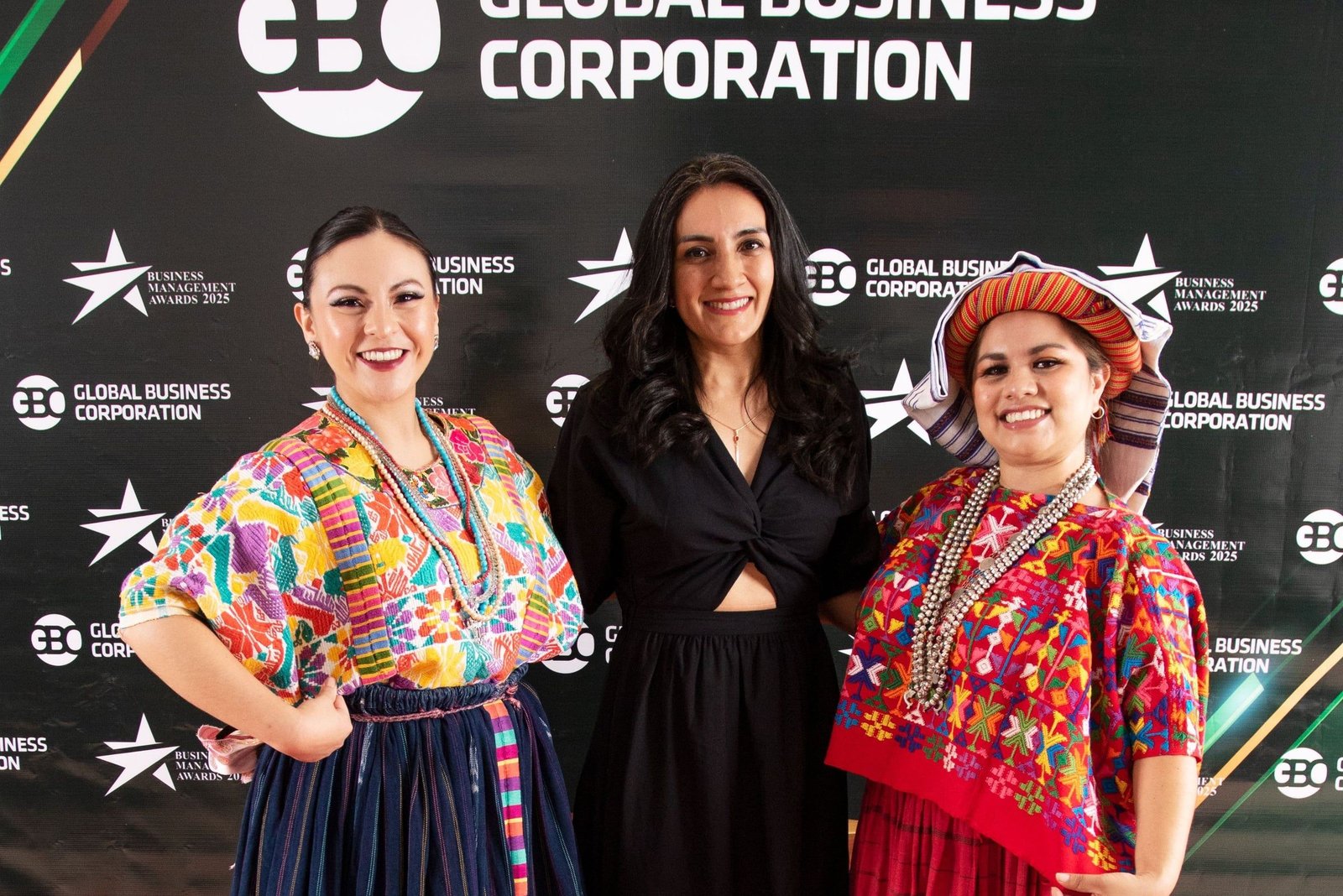 Invitadas, dos de ellas con traje típico guatemalteco, ante el photocall