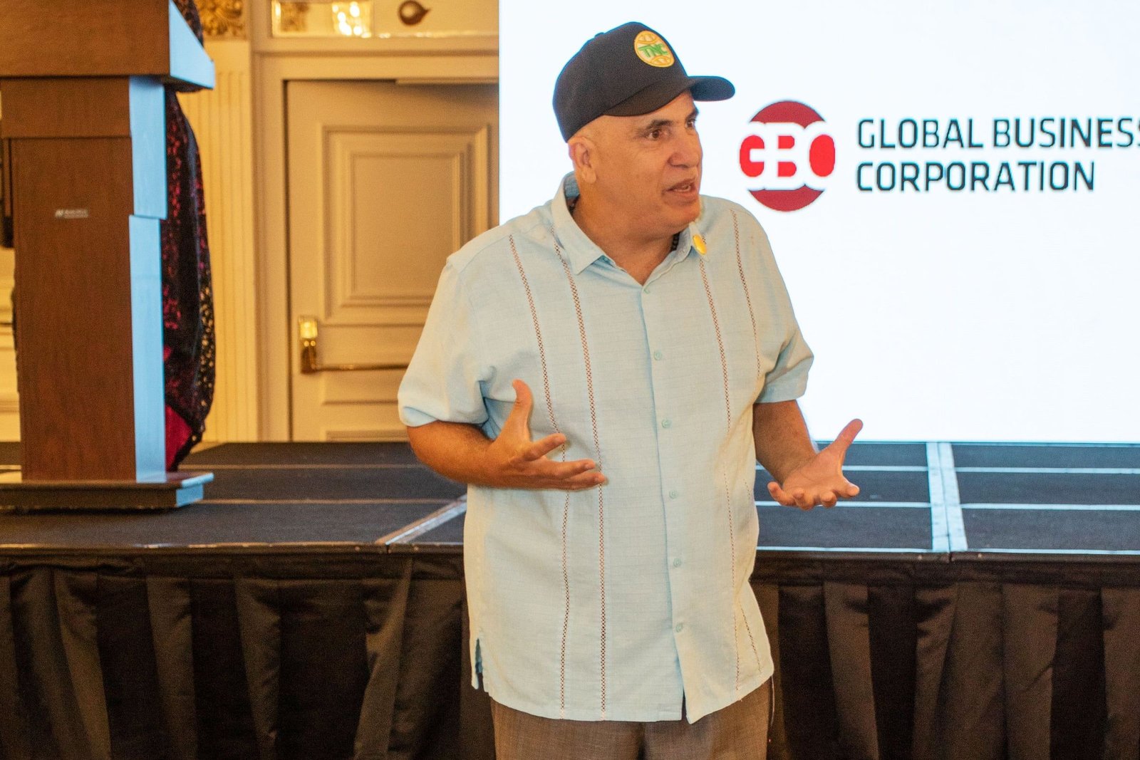 Conferencista durante un seminario, con la pantalla de Global Business Corporation